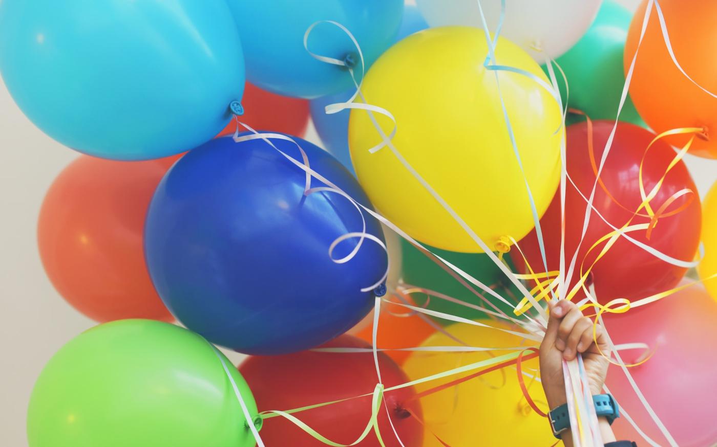 Hand holding a large bundle of balloons